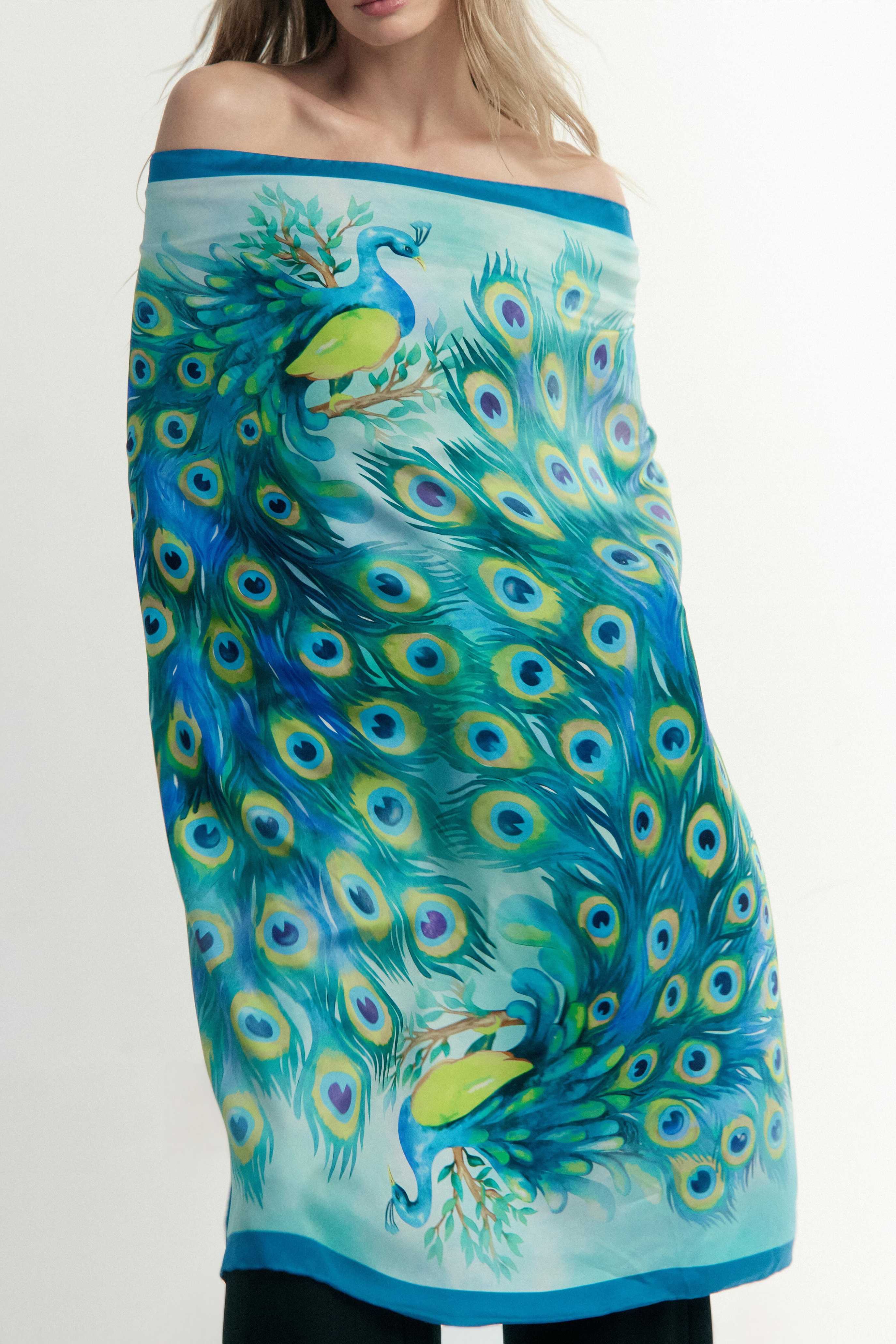 Preziosa silk scarf wrapped around the model's body, revealing its beautiful peacock blue design and mesmerizing hues — a bold, confident statement in Italian silk.